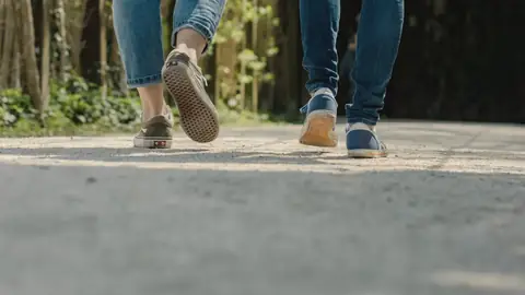 Dos personas caminando juntas, vistas de cintura para abajo