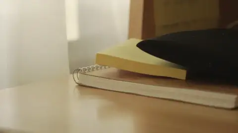 Una libreta sobre una mesa junto a una cortina