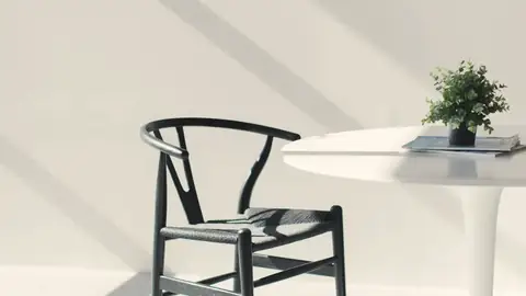 Una silla y una mesa blanca con sombras de ventana