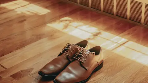 Unos zapatos en el suelo de madera, al sol
