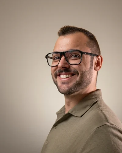Adrián Cuñat Andrés de tres cuartos, con polo verde, mirando a cámara y sonriendo